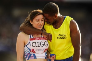 Guide runner Mikail Huggins puts arm around Libby Clegg after Hampden gold